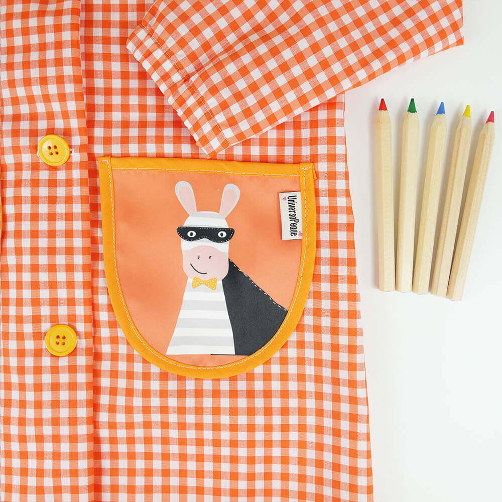 bolsillo del babi de botones naranja con el diseño de un héroe